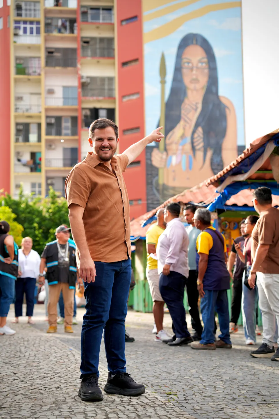 Renato Junior em uma rua do Centro, diante de um prédio com mural de uma mulher indígena